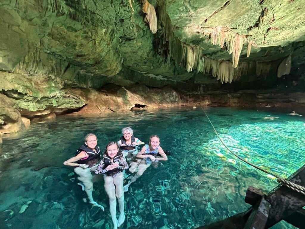Family swimming in a cenote during a Progreso Mexico cruise excursion